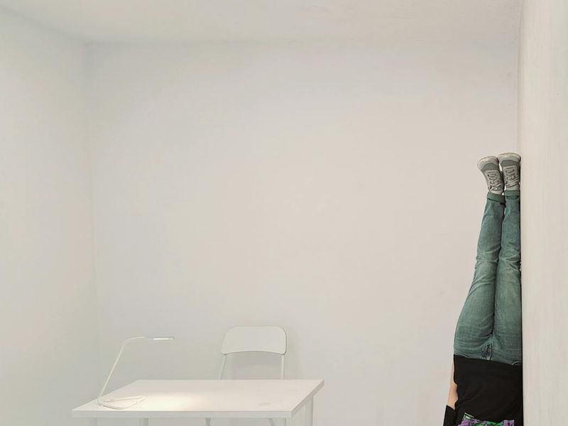 Person performing a smooth yoga transition in a bright room.