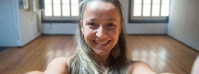 Wide view of an empty yoga studio with large windows.